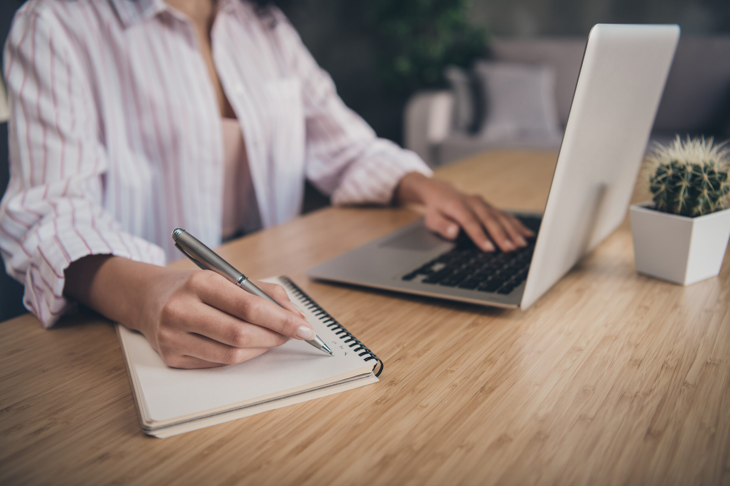 Cropped photo portrait of woman writing making list taking notes in notepad working on laptop indoors notizen